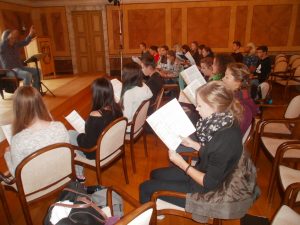 Chefdirigent Hans Richter unterweist die Chor-Workshopteilnehmer des Regentalgymnasiums im Schlosssaal.